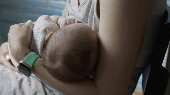Young Woman Feeds Breast Milk to Her Newborn Baby Closeup