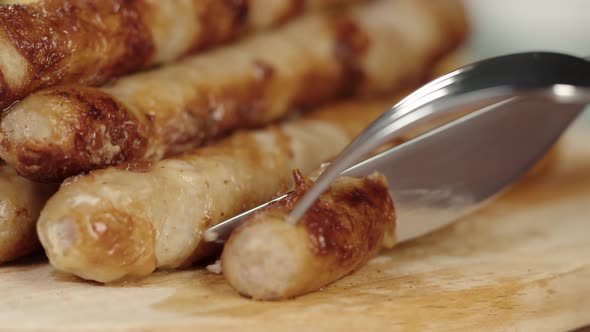 Taking Smoked Sausages with Fork and Cutting Closeup Using Cutlery