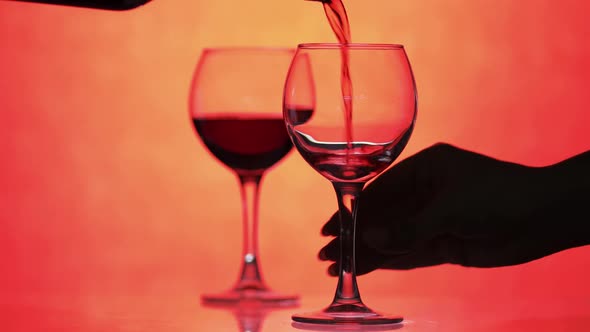 Rose Wine. Red Wine Pour in Wine Glass Over Orange Background