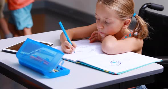 Disabled schoolgirl studying in classroom