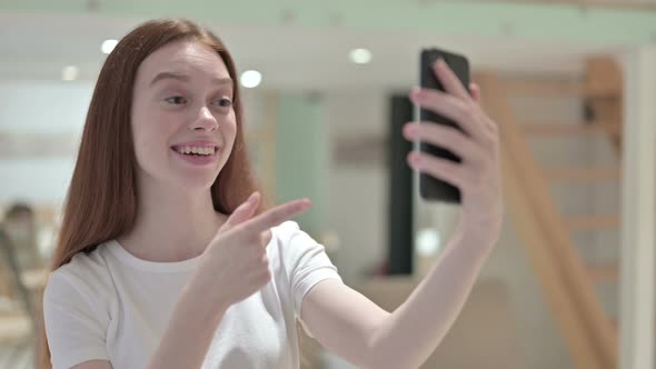 Portrait of Redhead Young Woman Doing Video Chat on Smartphone