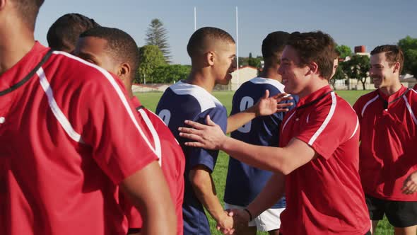 Rugby players meeting opposing team on the field