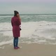 Lonely Girl Stands Near the Sea White Foam on the Shore of the Cold Winter Sea on a Foggy Day - VideoHive Item for Sale