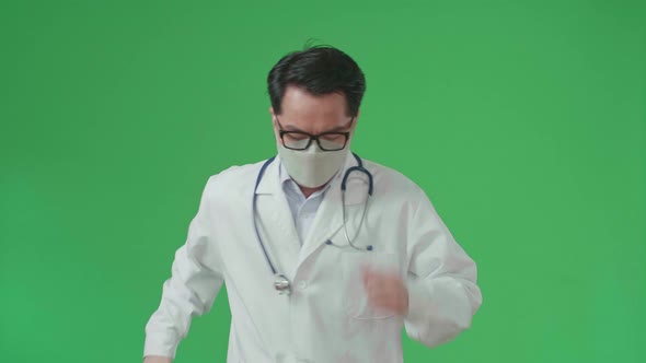 The Front View Of Asian Doctor With Stethoscope Wearing Mask, Running On Green Screen