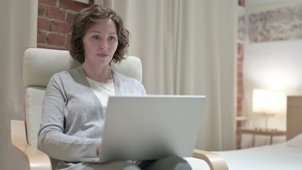 Old Woman Using Laptop in Bedroom