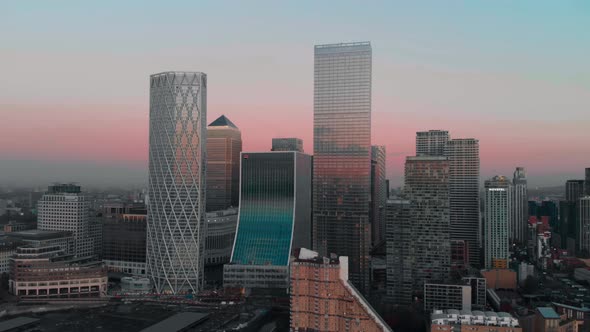dolly forward Drone aerial shot towards London Canary Wharf buildings at sunset