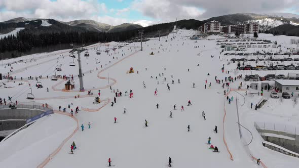 Aerial View on Lot of People Skiing on Ski Slopes Near Ski Lifts on Ski Resort