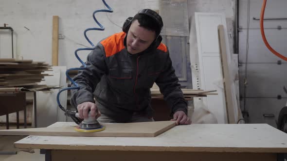 A Worker Listens to Music and Dances While Grinding Wood