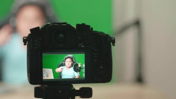 Camera Display Of Little Boy Hold Phone And Talking To Camera While Live Stream On Green Screen
