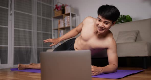 Man using laptop and doing side plank