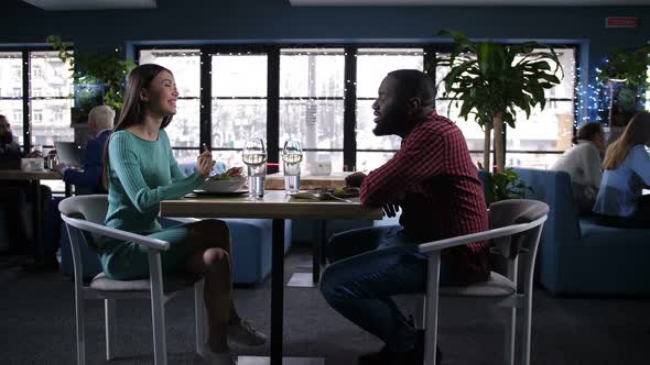 Diverse Couple Eating, Communicating in Restaurant