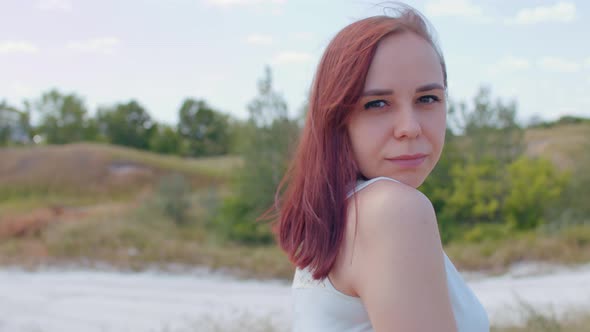 Portrait of Young Female in White Dress in Hilly Terrain