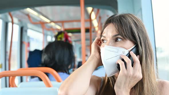 Young Woman in Facial Protective Mask Talking on the Phone, Riding in Public Transport. Woman in alt