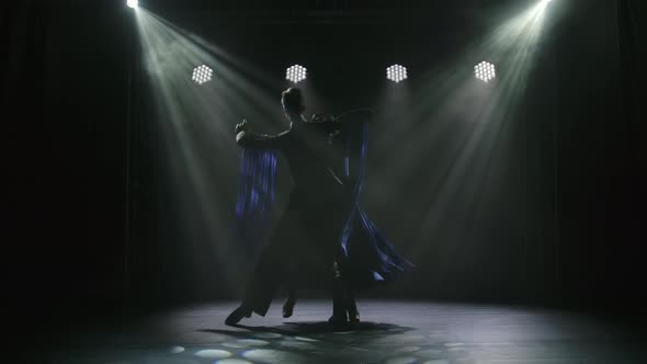 A Silhouette of a Couple Who Is Dancing the Classic Ballroom Dance Waltz in a Dark Studio. Dancers