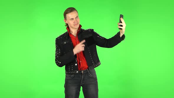 Guy Makes Selfie on Mobile Phone Then Looking Photos on Green Screen