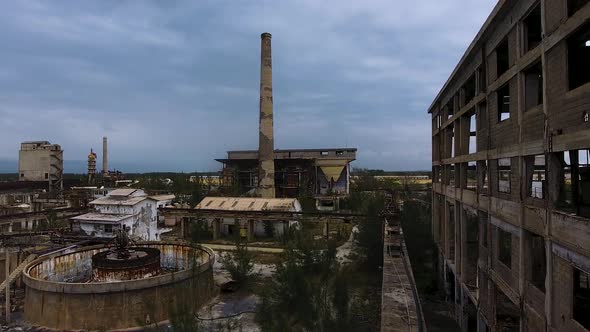 Drone shot of a devastated and abandoned factory on a cloudy day