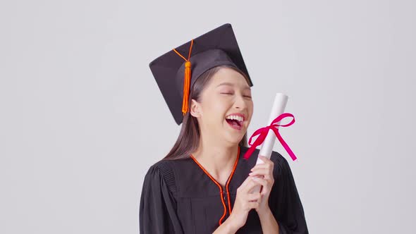 Beautiful Attractive Asian woman graduated in cap and gown smile