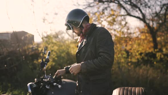 a Man Motorcyclist Wears a Helmet and Ride on His Motorcycle