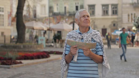 Senior Male Tourist Exploring Town with a Map in Hands. Looking for the Route