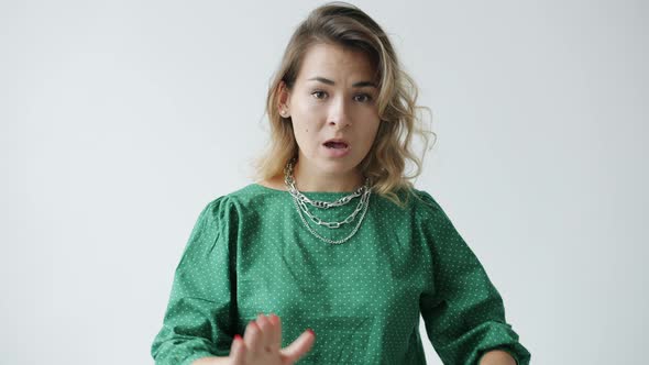 Portrait of Dissatisfied Young Woman Shaking Head and Gesturing Meaning No on White Background