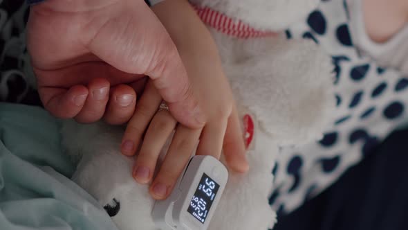 Vertical Video Close Up of Father Holding Sick Daughter Hands After Suffering Medical Surgery