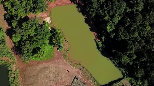 Bird's eye view slowly descending over a commercial fishing pond on a fish farm in the Tocantins reg