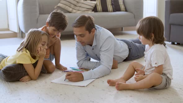 Sibling Kids and Dad Sitting and Lying on Warm Floor