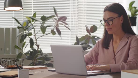 Attractive Businesswoman Working on Laptop in Office