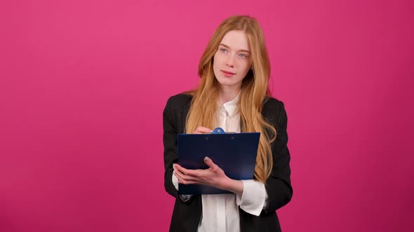 Portrait of Young Businesswoman Write on a Paper Isolated on Pink Background