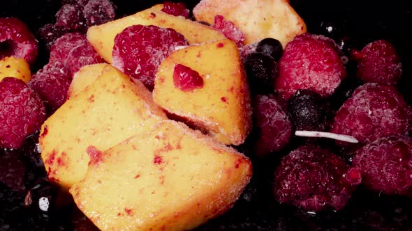 Close up shot showing defrosting frozen mix fruits,ice melting,time lapse footage.