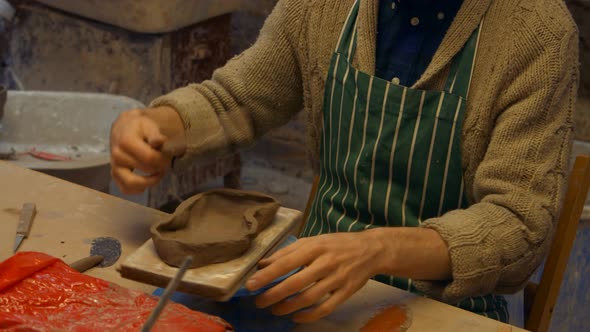 Potter flattening a clay