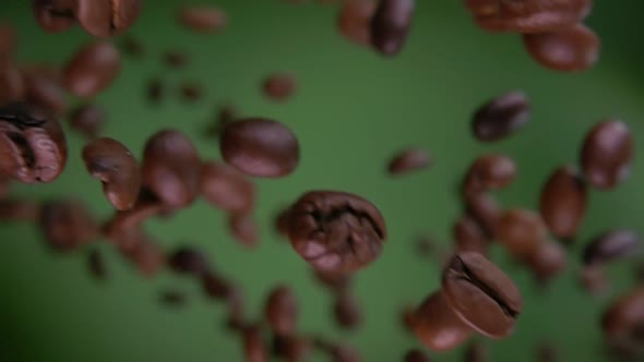 Close-up of Arabica Coffee Beans Flying Diagonally on the Olive Green Background