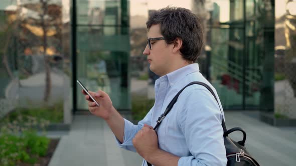 Portrait Profile Shot of Man in Eyeglasses and Blue Shirt Walking Along the Street