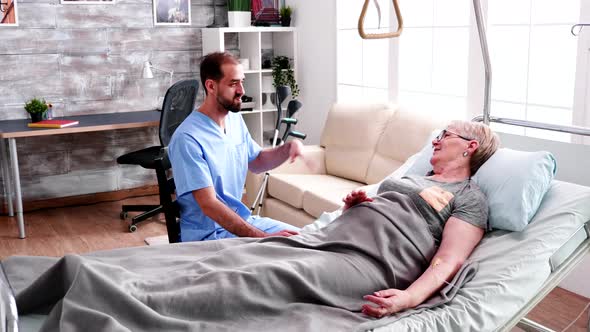 Male Nurse Visit Old Woman Lying in Bed