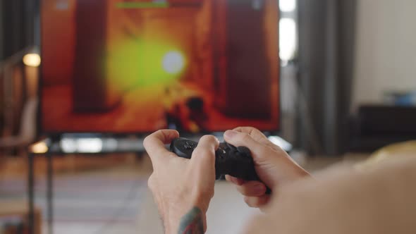 Hands of Man Playing Shooter Game on TV at Home