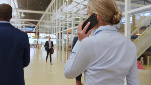 Businesswoman using a smartphone walking in a conference foyer