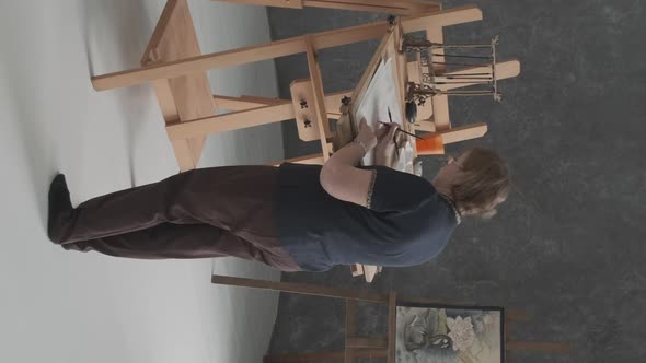 Elderly Female Artist Painting in Art Studio