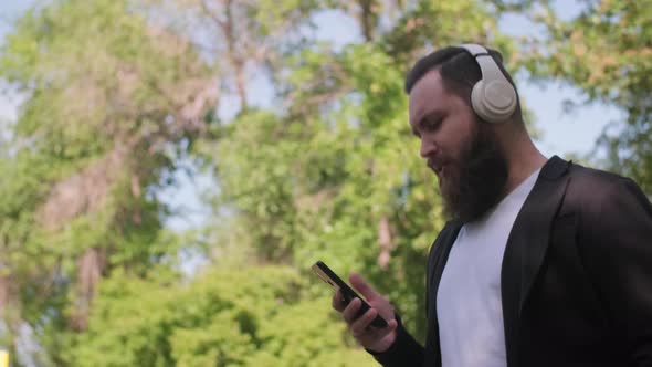 Bearded Man Enjoying Music and Walking Outdoors