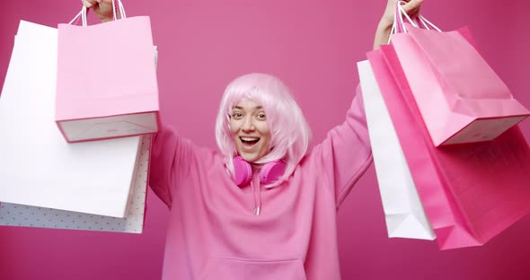 Happy Girl Enjoys After Shopping with Colorful Bags in Pink Colour Concept