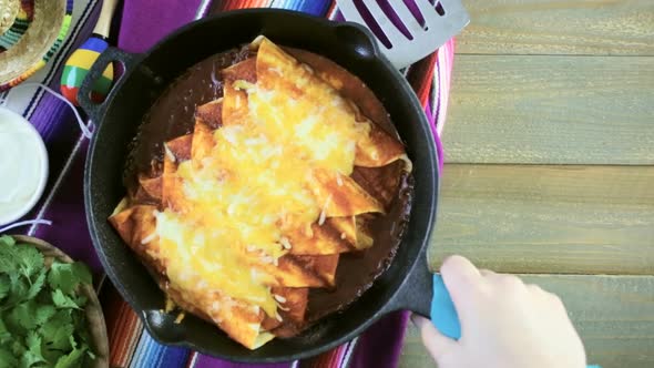 Homemade chicken enchiladas in cast iron frying pan.