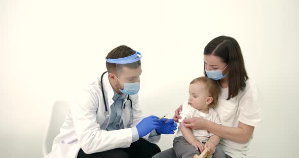 Mother with Kids Vaccinating at Pediatrician Office