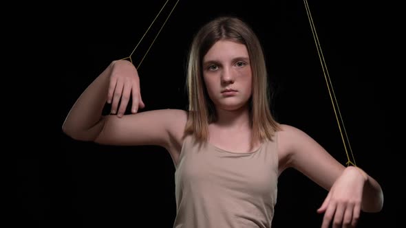 Front View Sad Teenage Girl Looking at Camera Standing at Black Background with Ropes on Hands