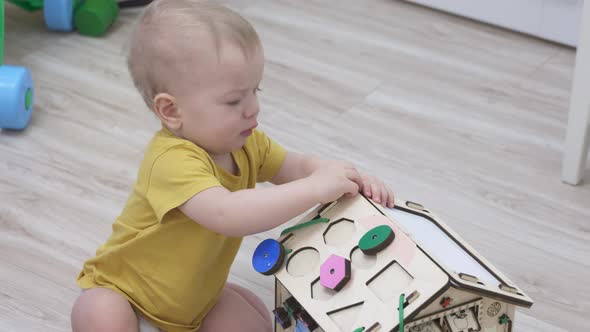 Child Having Fun Playing with Wooden Busy Board Happy Kid Play with Educational Learning Toy Enjoy