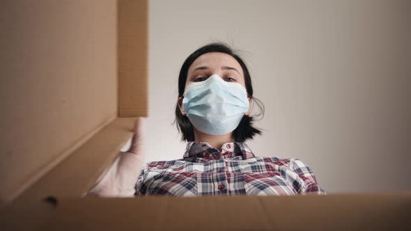 Young Woman Carefully Opens Box Delivery From Online Store