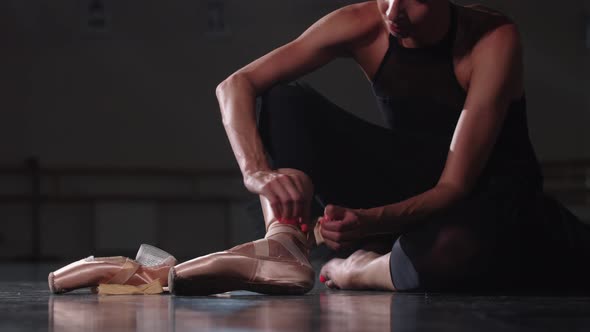 Young Woman Puts Off Her Pointe in the Studio