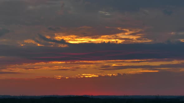 Scenic time lapse view of beautiful golden sunset with pink and blue clouds