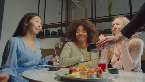 Diverse Female Friends Deciding Who Paying Bill at Cafe
