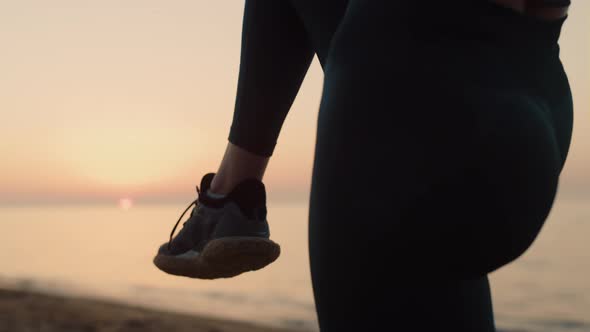 Unknown Girl Standing One Leg Holding Knee at Sunset