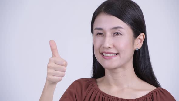Face of Happy Beautiful Asian Woman Giving Thumbs Up