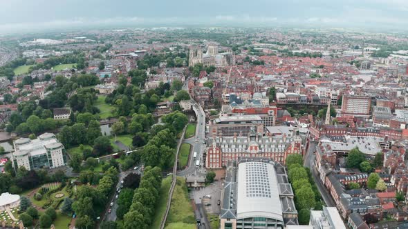 Descending drone shot looking towards York Minster Cathedral over city wall cloudy day